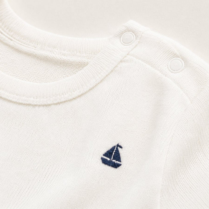 Close-up of the Petit Bateau sailboat embroidery on white knitwear